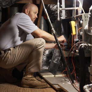 Dominion technician working on HVAC system in Michigan basement