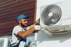 Repairman for Dominion Service Company installing an Air Conditioning unit 