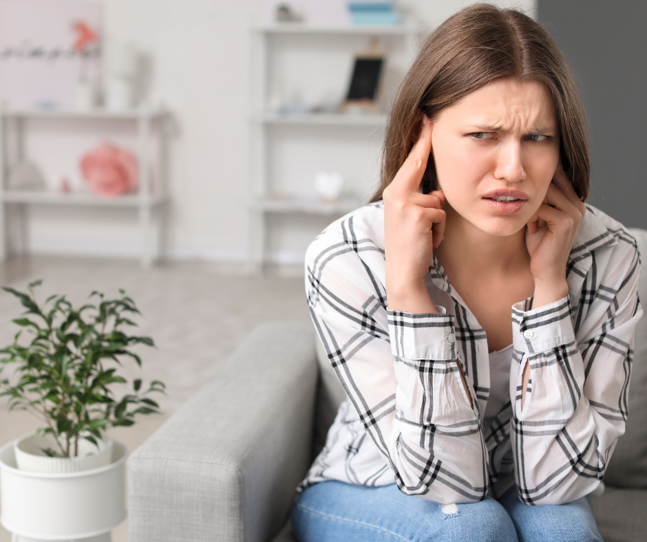A woman covering her ears from loud noises 
