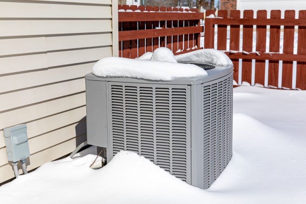 Outdoor HVAC unit covered in snow outside Michigan home