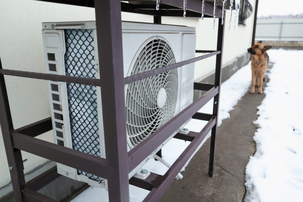 Heat pump outside home during winter