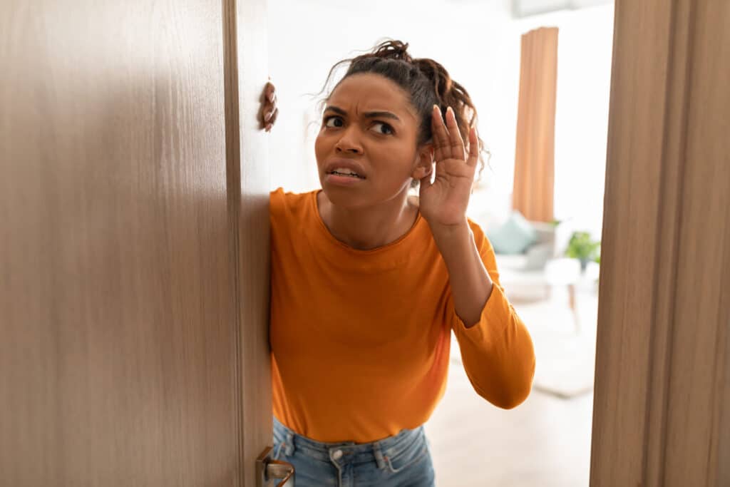 Woman listening to strange sounds coming from furnace